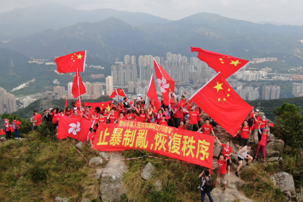 數十名愛國愛港人士昨日自發登山A將一面巨幅國旗懸挂在獅子山頂C]中通社資料圖^