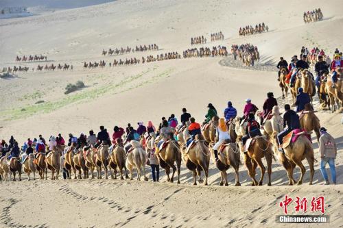 國慶長假期間A國際旅游名城甘肅敦煌著名景區鳴沙山月牙泉旅游迎來u高峰模式vC據統計A10月3日A該景區接待中外游客達到3萬人次A掀起金秋敦煌旅游新高潮C]中新社圖^