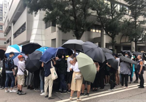 兩名被告離開法院時A有大批聲援人士舉起傘陣協助離開C]來源G香港電台^