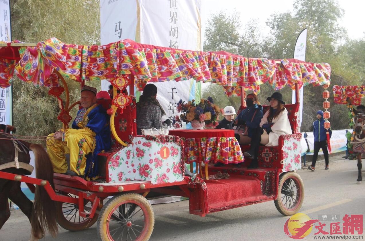 圖為遊客乘坐民族風情濃郁的馬車參加胡楊盛會 (應江洪 攝)