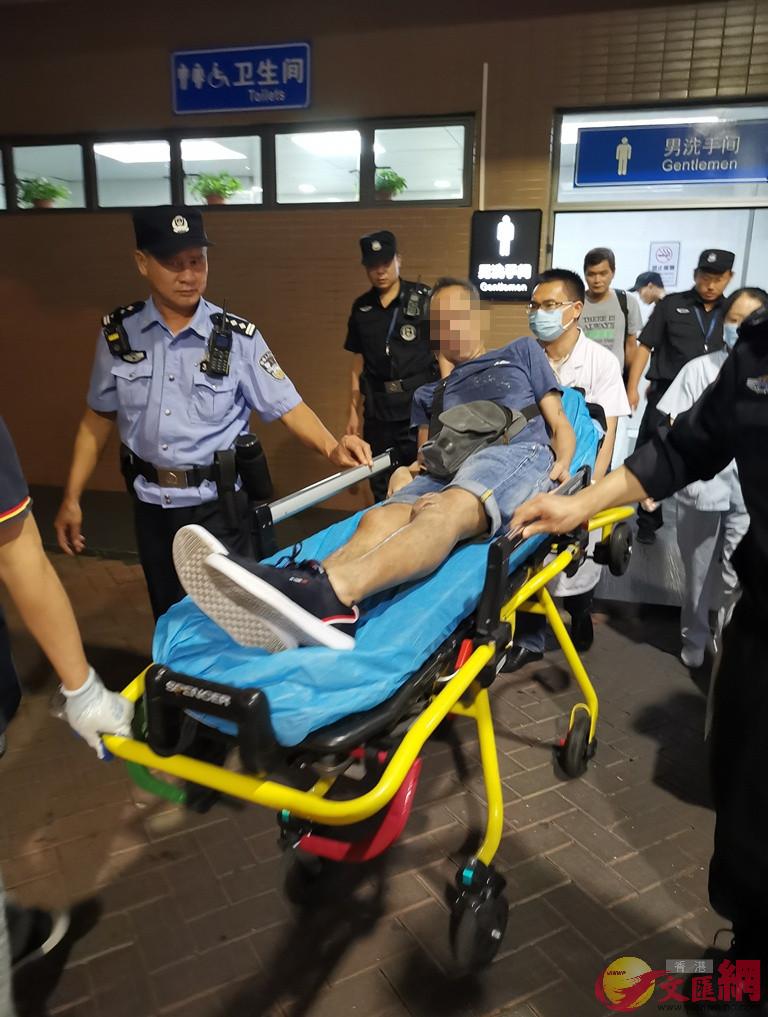  皇崗邊檢民警協助醫護人員將腦梗昏厥香港旅客救治後安全轉移上救護車]記者 何花 攝 ^