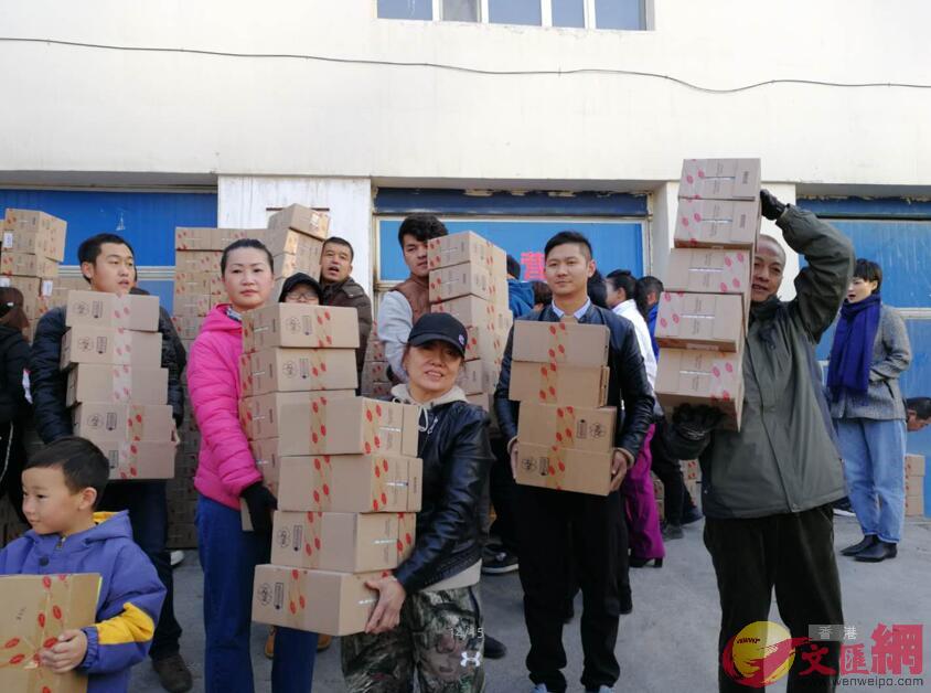 圖為捐贈活動啟動現場志願者們搬運物資(應江洪 攝)