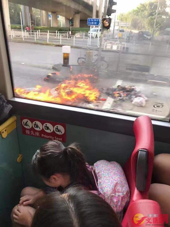 巴士駛過被暴徒縱火的路口A有學童被驚嚇低頭C(大公文匯全媒體記者攝)
