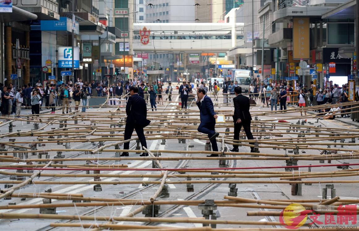 11月13日下午A蒙面黑衣人在香港中環德輔道中設置u竹竿陣vA導致交通要道中斷C