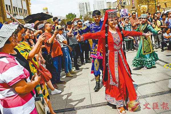 位於新疆烏魯木齊市二道橋的新疆國際大巴扎A身着華麗服裝的演員跳起歡快的舞蹈A吸引大批遊客駐足圍觀C 資料圖片
