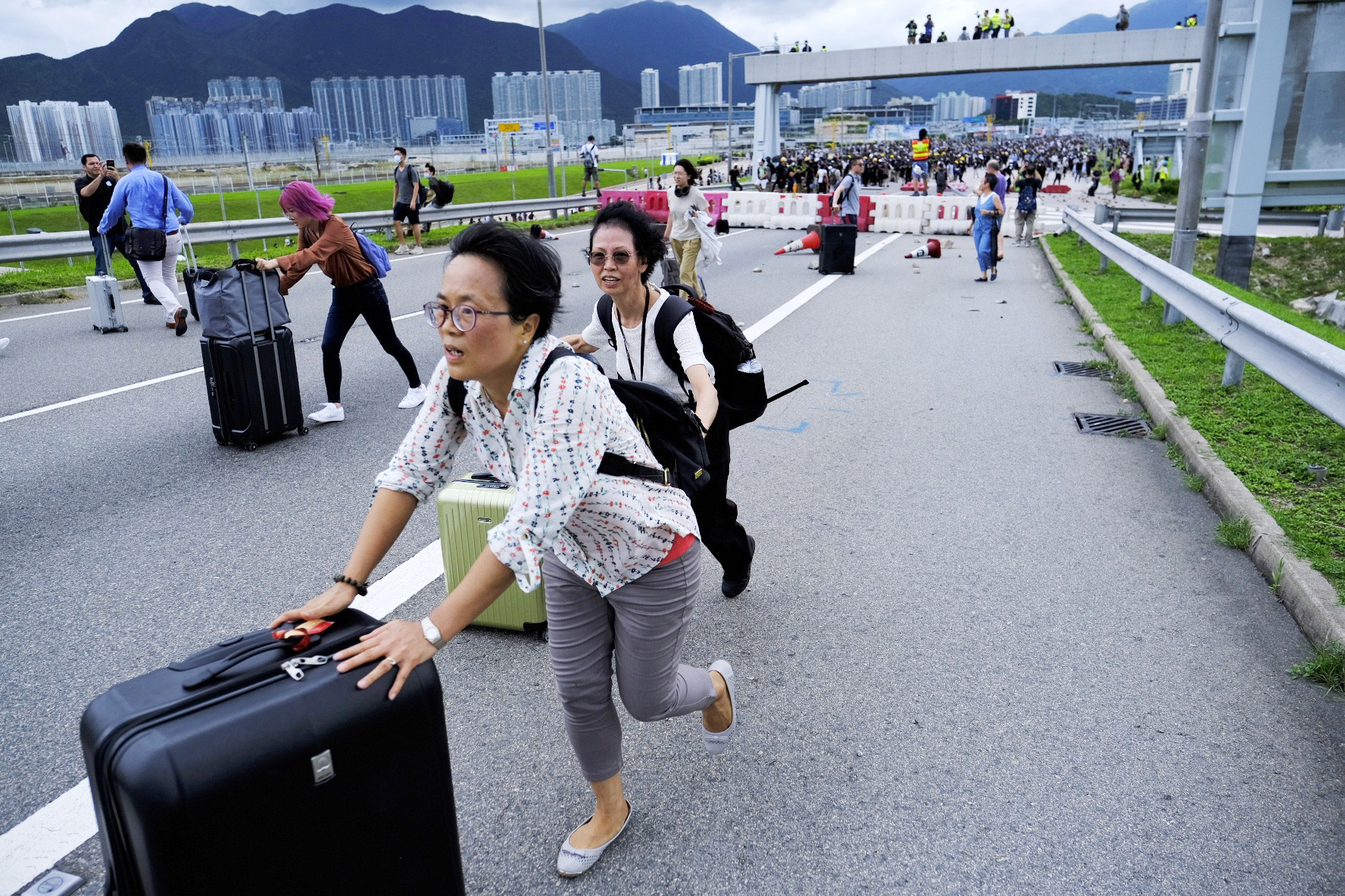 9月1日A在香港國際機場A由於暴徒堵塞交通A旅客只能拖著行李跨越路障走進機場C]新華社資料圖片^