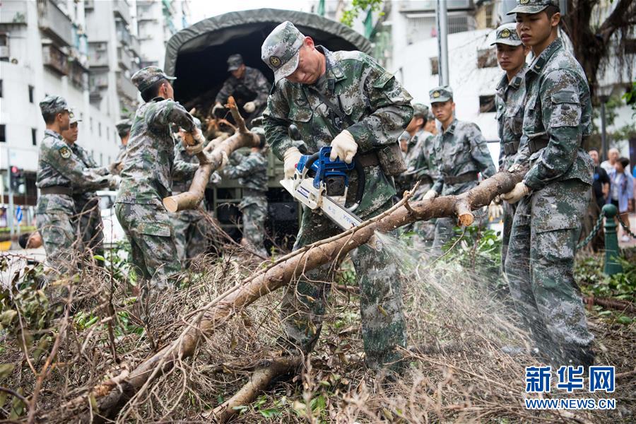 解放軍駐澳門部隊協助特區政府救助颱風「天鴿」災害，清理被風吹倒的樹木(2017年8月27日攝)。新華社