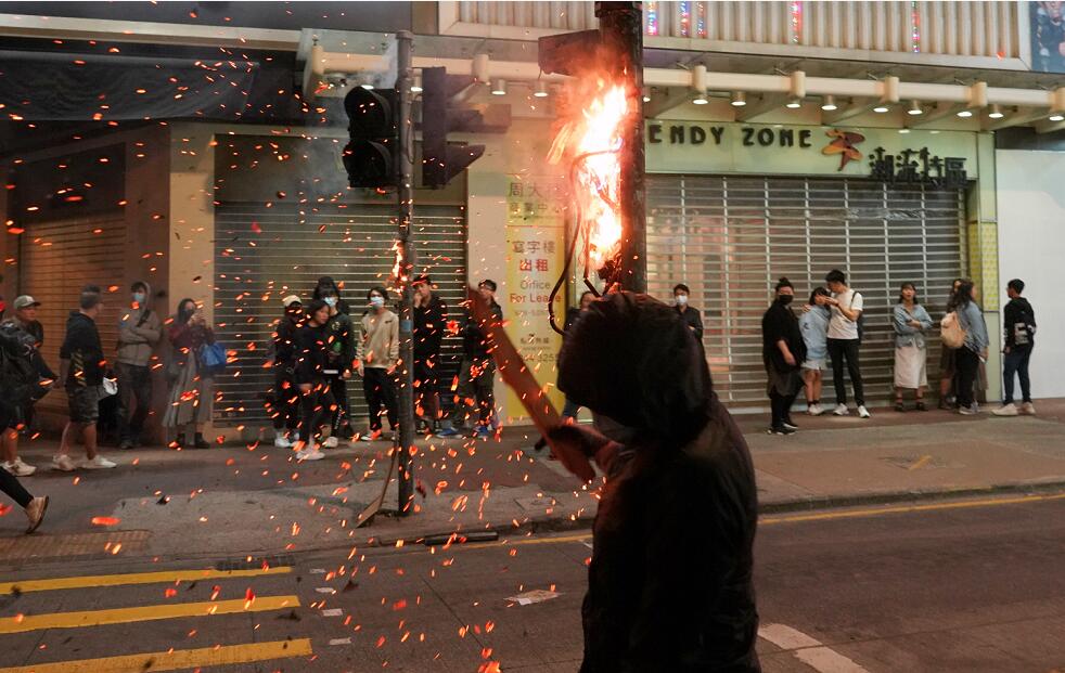 陳茂波表示A默許和放任才是毁掉香港的元凶C圖為12月25日凌晨A黑衣人在旺角縱火焚燒交通燈(中新社資料圖片)