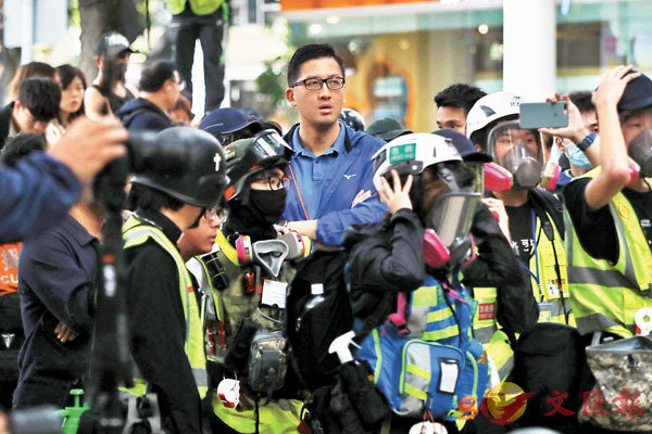 雙料議員林卓廷躲藏在急救員身後觀察。 香港文匯報記者 攝