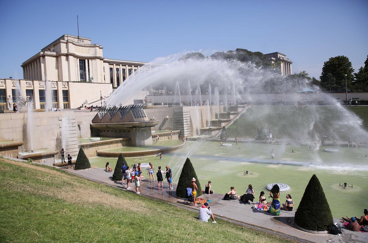 去年法國錄得破紀錄的攝氏46度A在法國巴黎人權廣場附近A人們在噴泉裡消暑納涼C(新華社資料圖)