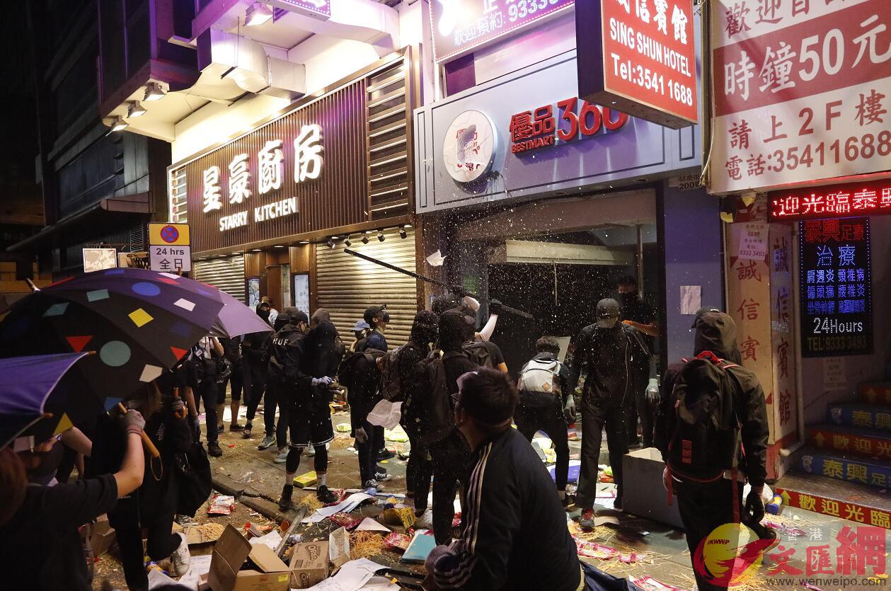 在過去7個月中A香港不少商鋪被黑衣暴徒破壞]香港文匯報資料圖^