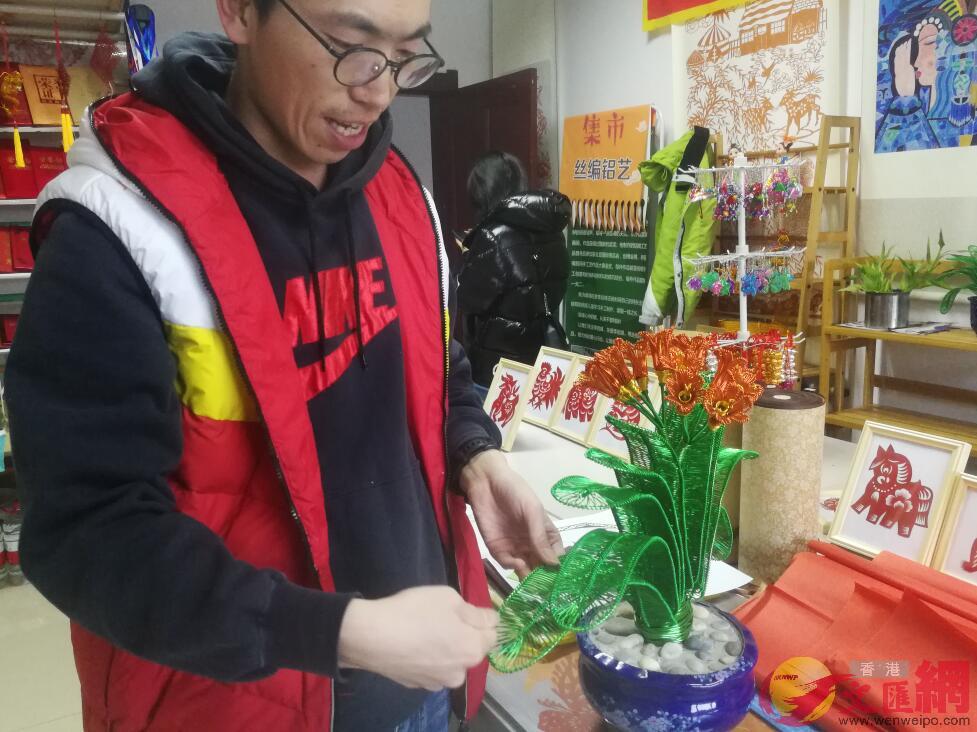 李岩峰展示彩色鐵絲編織的君子蘭C本網記者盧冶攝
