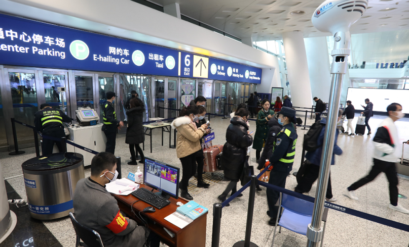 1月21日，在武漢天河機場，工作人員對旅客進行體溫檢測（新華社）