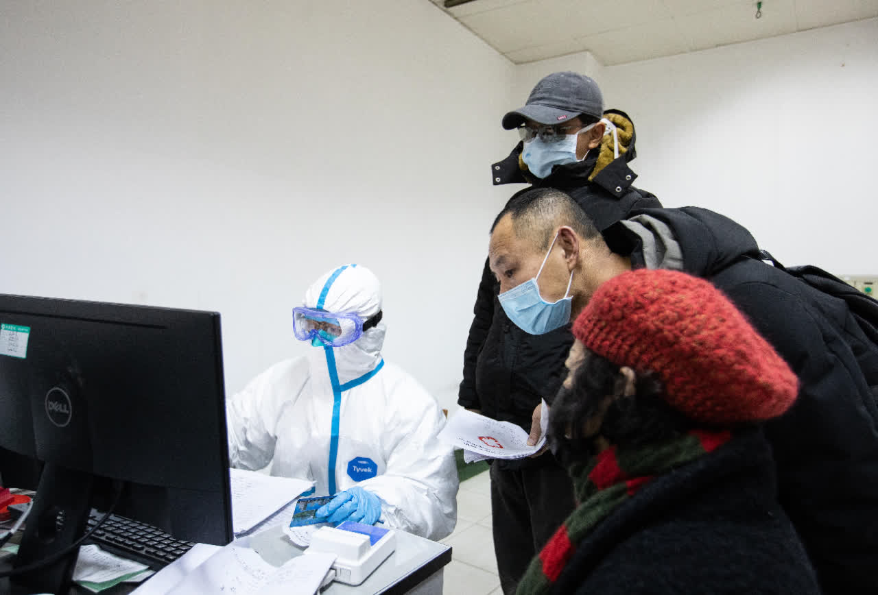 武漢華中科技大學附屬同濟醫院已啟動三級預檢分診機制，圖為醫務人員身著防護服接診。 (中新社)