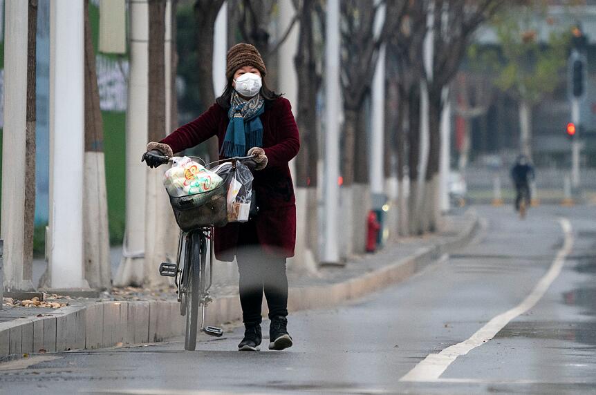 世衞促中國盡快確認新型肺炎的病源及傳播潛力。圖為1月26日的武漢，街頭冷清，出行市民佩戴口罩（新華社資料圖片）