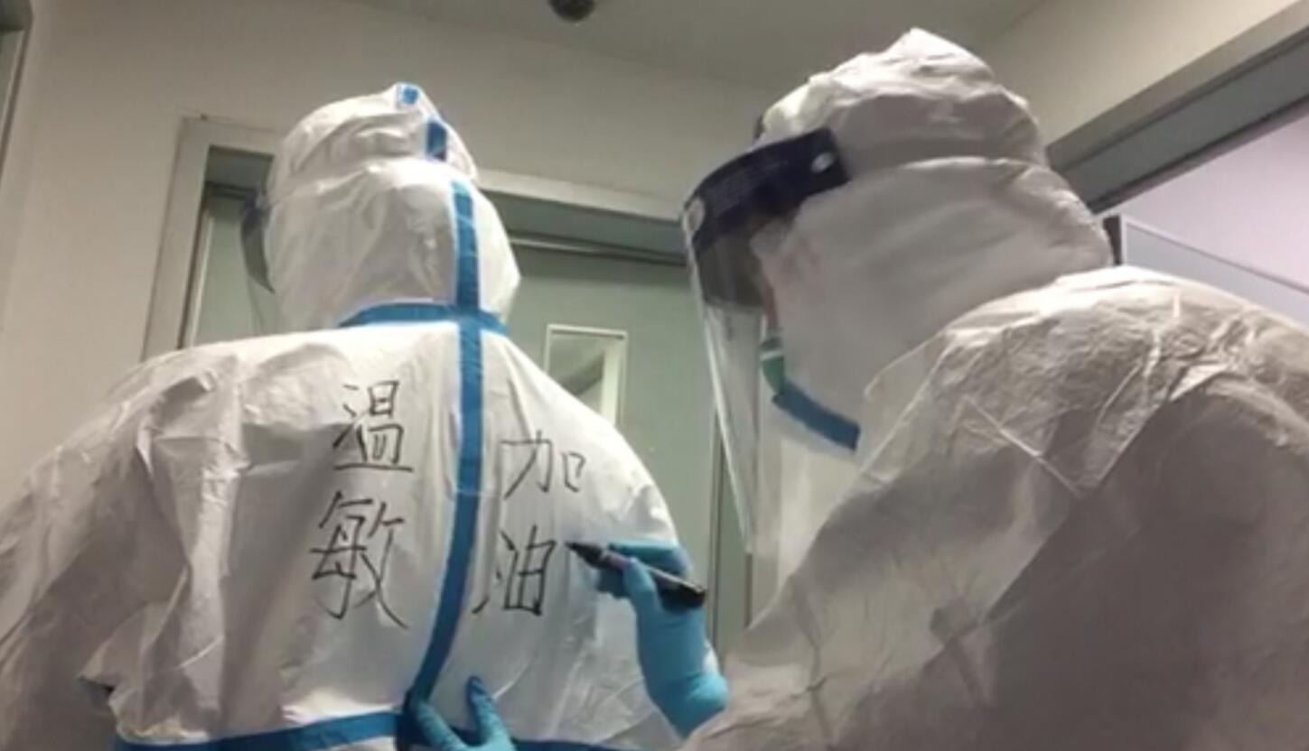 深圳市第三人民醫院護理部副主任溫敏與同事相互在防護服上寫名字(受訪者供圖)