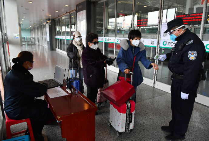 專家再次呼籲外出務必戴口罩。圖為西安火車站檢疫人員正為旅客量體溫（新華社）
