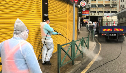 澳門工作人員在商舖周圍清潔消毒]中新社圖片^