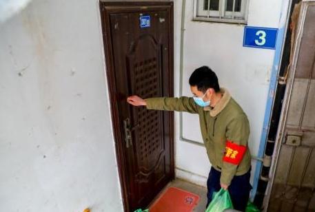 2月10日，武漢市江漢區新華街取水樓社區為轄區的老人送菜上門，社區工作人員把菜放在門口，敲門提醒老人菜已送到(中新社)