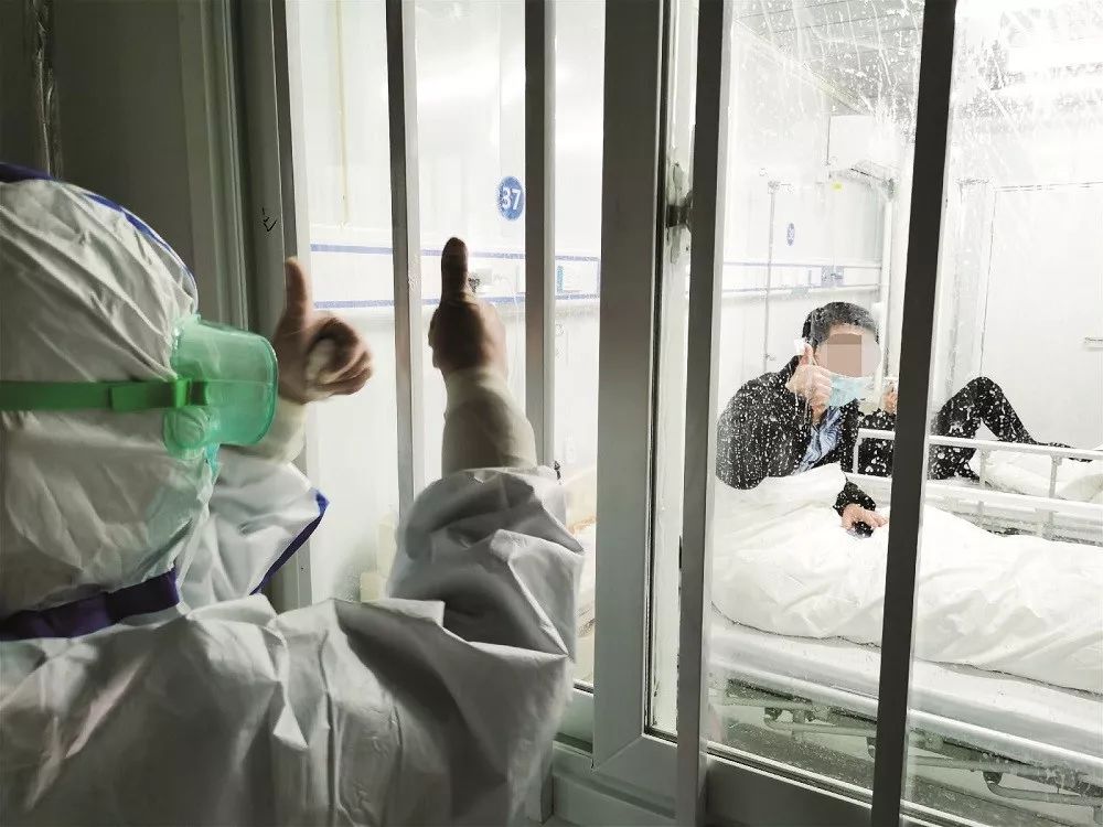 2020年2月9日晚A武漢雷神山醫院接收了第二批新冠肺炎患者A總入住患者達80餘人C圖為醫護人員為患者鼓勁加油C圖/中新