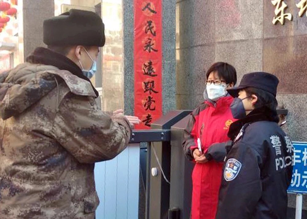 北京某社區工作人員向返京人員介紹隔離新政A嚴格人員出入]受訪者供圖^