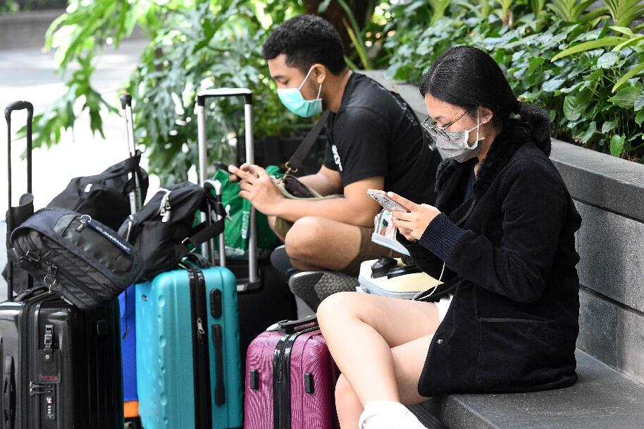 新加坡樟宜國際機場戴著防護口罩的旅行者(法新社資料圖)