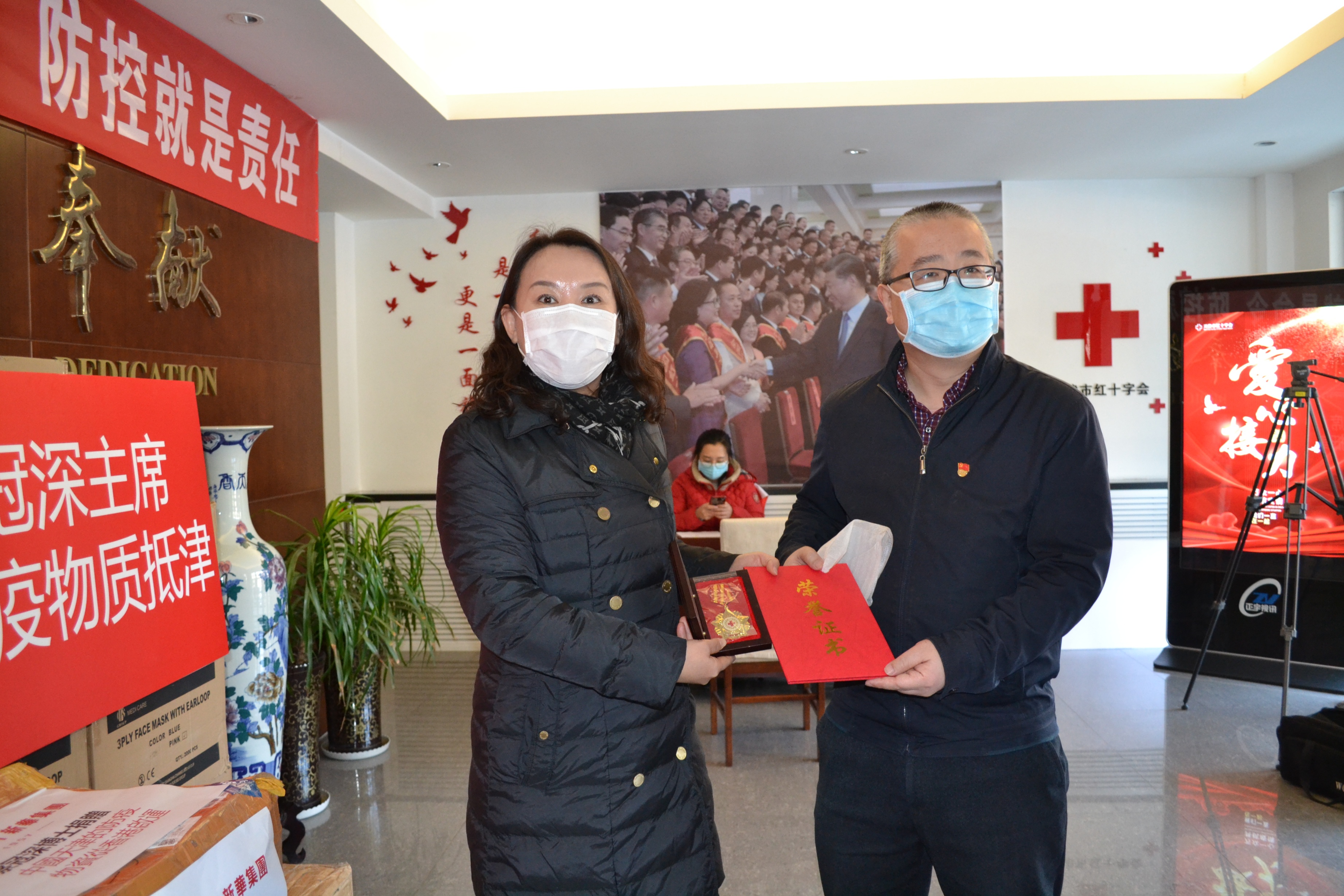 新華集團天津公司總經理張琪代表新華集團主席蔡冠深向天津市紅十字會賑濟救護部移交防疫物資(受訪者供圖)