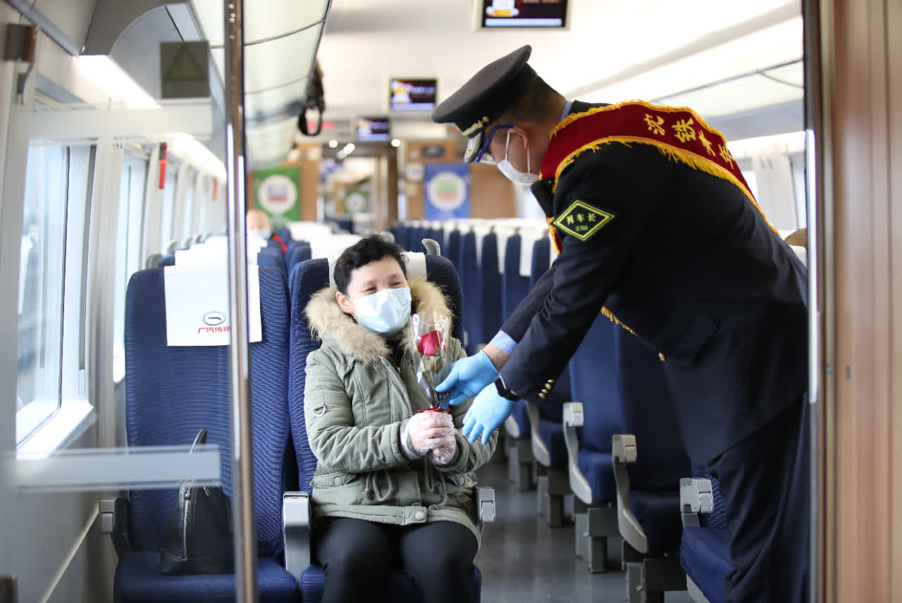 高鐵列車上的乘務員佩戴著口罩和護目鏡A為旅客送上手語舞蹈m謝謝你nC(中新社)