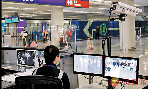 專家認為香港需完善堵塞疫症輸入的政策C圖為衛生署人員在香港機場監測入境旅客的體溫C 資料圖片
