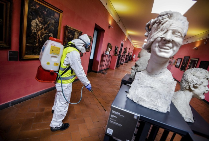 意大利那不勒斯博物館一名工人噴灑消毒劑A進行消毒操作C]美聯社資料圖片)