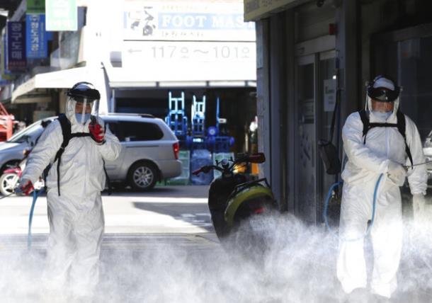 首爾工作人員在街頭噴灑消毒]美聯社資料圖片^