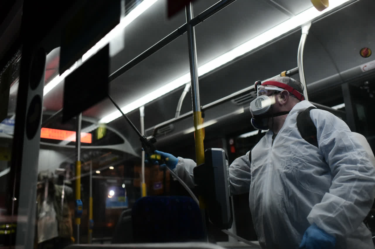 圖為以色列衞生人員給巴士消毒(新華社)