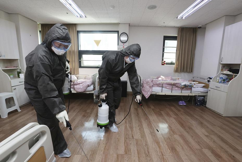 工作人員在韓國一間養老院內消毒]美聯社^