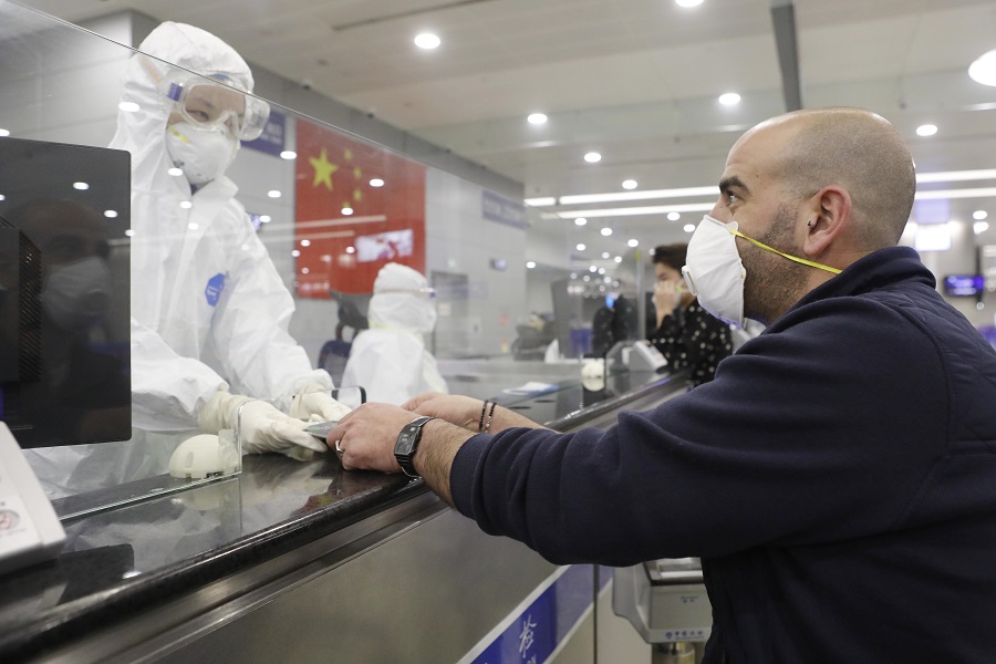 上海邊檢民警核查入境旅客個人信息後返還護照]中新社資料圖^