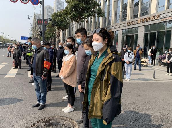 武漢市防空警報鳴響，汽車停車鳴笛，民眾在街頭肅立默哀