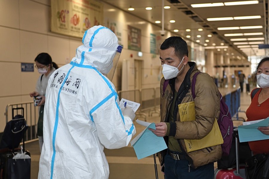 4月3日，在深圳灣口岸入境大廳，海關工作人員指導入境旅客填寫健康申明卡，嚴防疫情輸入輸出（新華社圖）