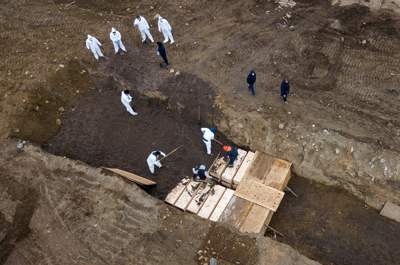紐約布朗克斯(Bronx)區對開赫特島(Hart Island)一座市政府管理的u萬人塚vA工人忙於將棺木下葬(路透社圖片)