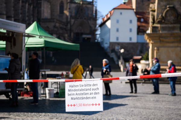 4月1日在德國中部城市愛爾福特一處市集拍攝的提示人們保持距離的標識C]新華社圖片^