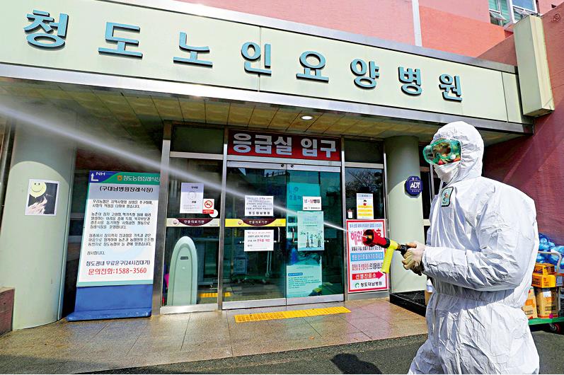 韓國有263名康復患者復陽C圖為韓國防疫人員在街上消毒]資料圖片^