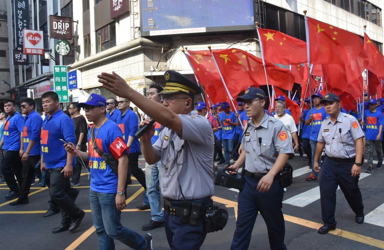 2017年10月1日A支持統一的台灣民眾人手一面五星紅旗A穿上藍衣A在台北街頭表達u我的國旗是五星紅旗v立場C這是活動過程中的遊行隊伍C