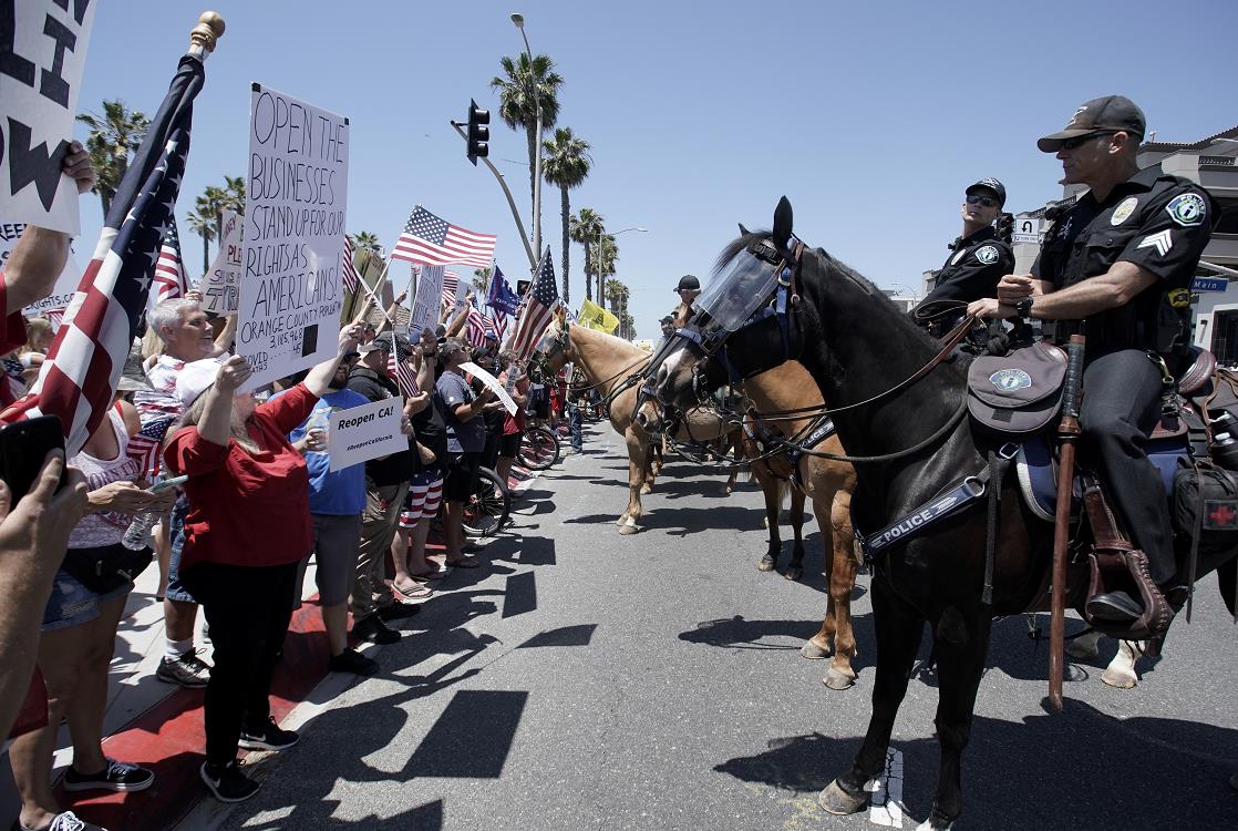在加州亨廷顿海滩A抗议者在人行道上示威(美聯社資料圖片)