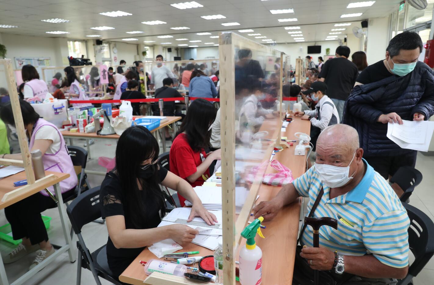 三重區公所7日開啟活動中心讓民眾申辦，以因應大批申請人數。圖片來源：台灣「中央社」