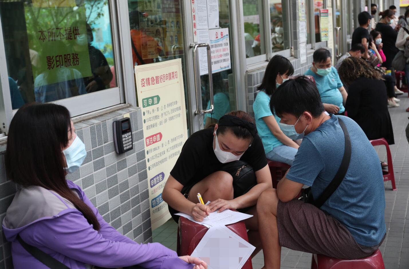 5月7日，新北市三重區公所排隊民眾預先填寫申請表格。圖片來源：台灣「中央社」