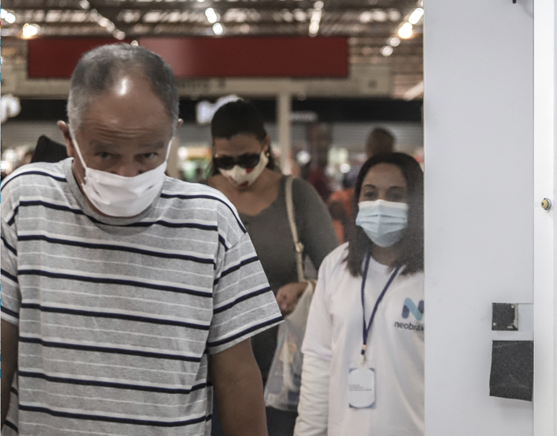 巴西聖保羅市一些地鐵站內加強措施，乘客排隊通過消毒裝置。（新華社資料圖片）