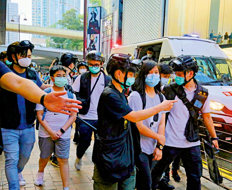 圖：一名年僅13歲宣稱自己為「學生義務記者」的男童(左二)被警帶離現場\大公報記者凱楊攝