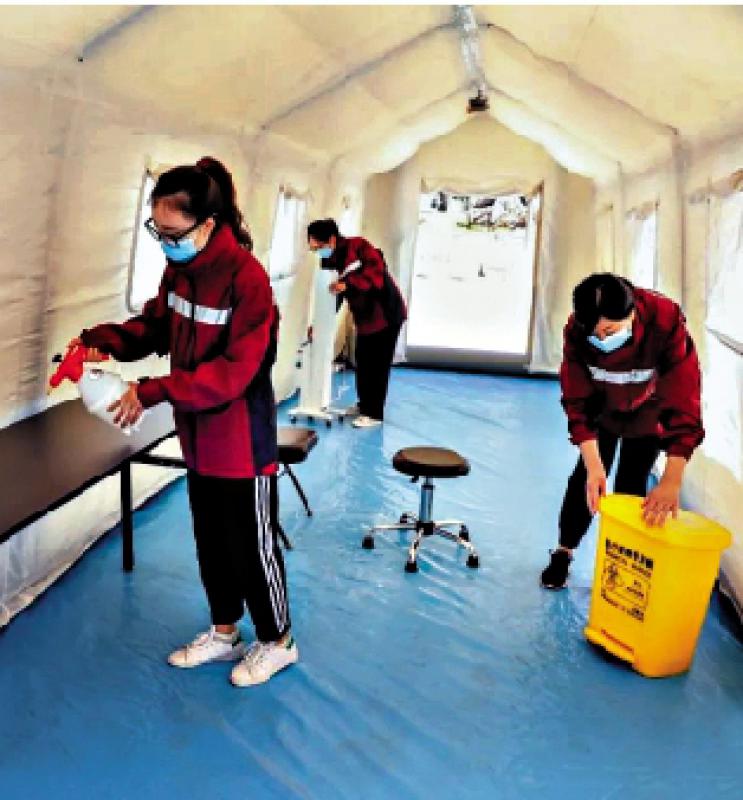 北京全國u兩會v駐地工作人員對核酸檢測點進行消毒\網絡圖片
