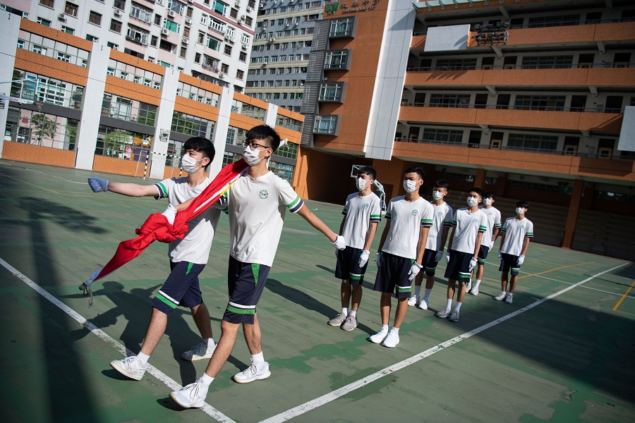 澳門約1.3萬名高中生本月4日正式返校復課C圖為澳門教業中學學生在操場舉行升國旗儀式]新華社資料圖片^