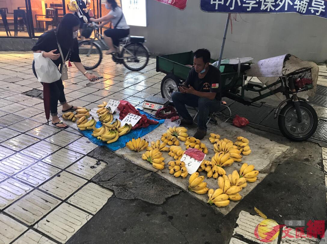 廣州將設置60個流動商販臨時疏導區C圖為6月5日A一名商販擺攤賣水果A消費者手機付款C記者敖敏輝攝