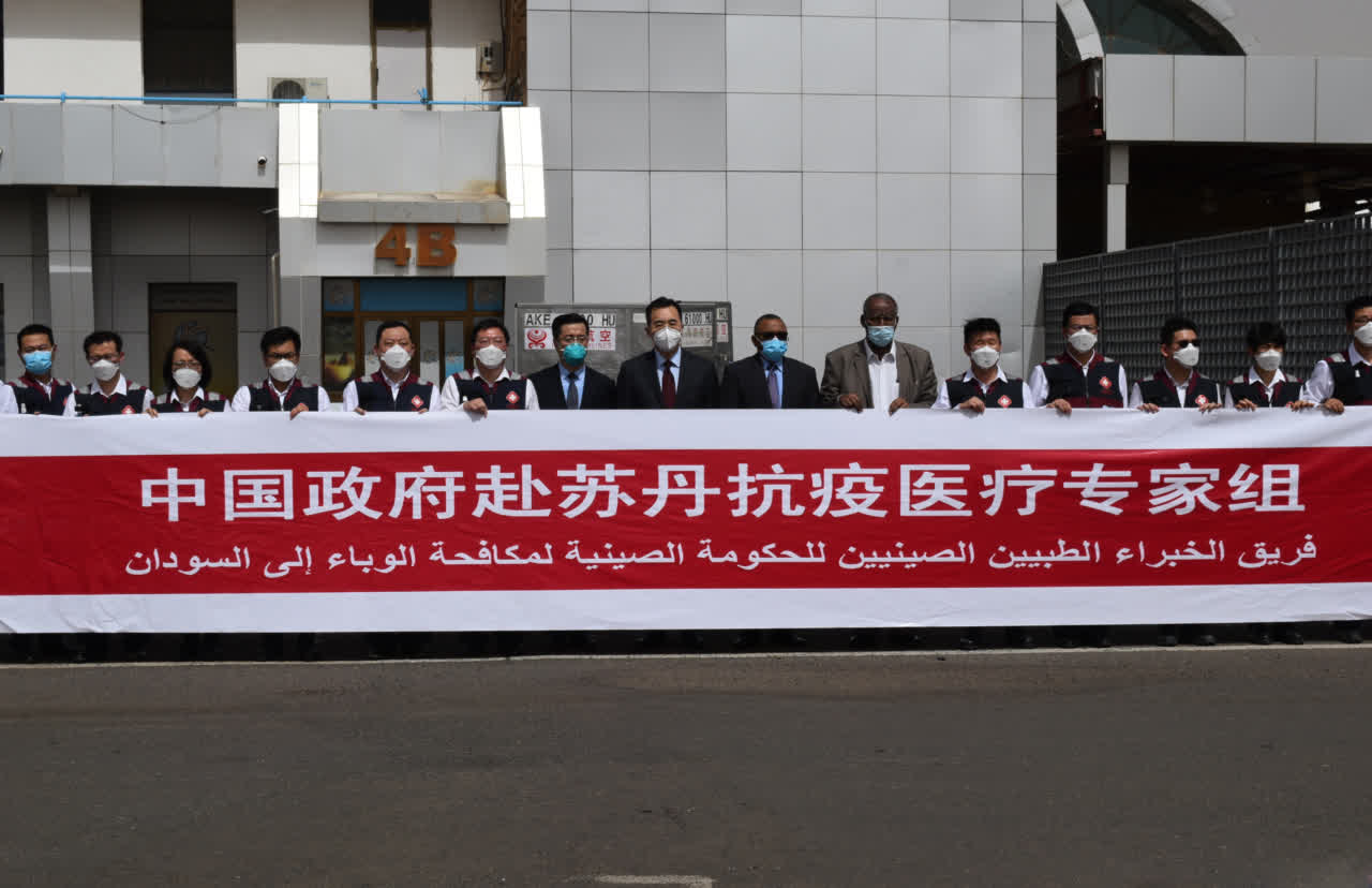 抗疫專家一行在喀土穆機場舉起中國國旗]受訪單位供圖^