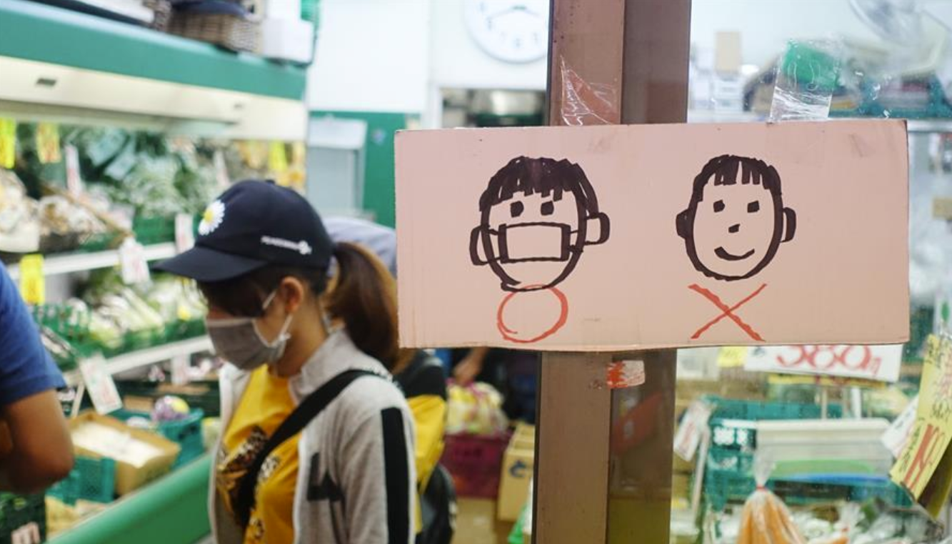 7月5日A在日本東京A一間商鋪門口貼着簡易標識A提示顧客戴口罩入場購物C 新華社